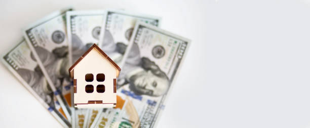istock toy house for dollar banknotes on the white background 1280856178
