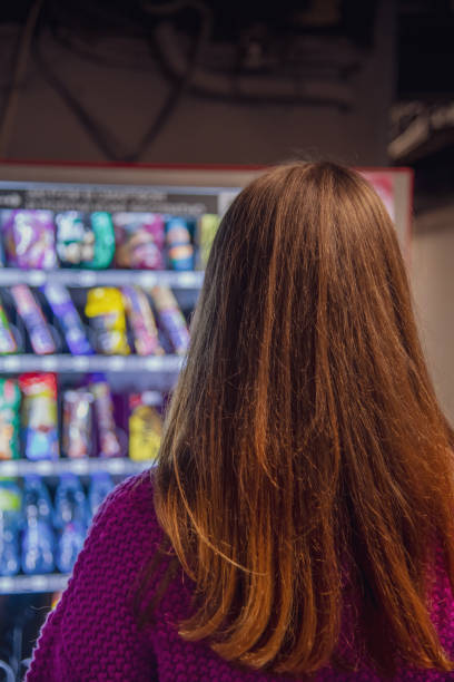 istock woman standing by snack vending machine 1280858828