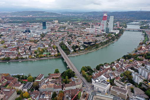 Basel with the river rhine. In the background visible the Roche Towers with several laboratories and factories. In the foreground the old town with the Minster of Basel. The  wide angle image was captured during autumn season.
