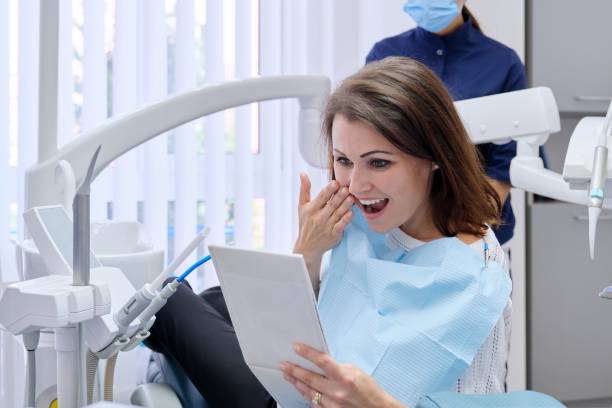 happy middle aged woman with doctor dentist looking in mirror at teeth - dental light dental equipment hospital professional occupation imagens e fotografias de stock