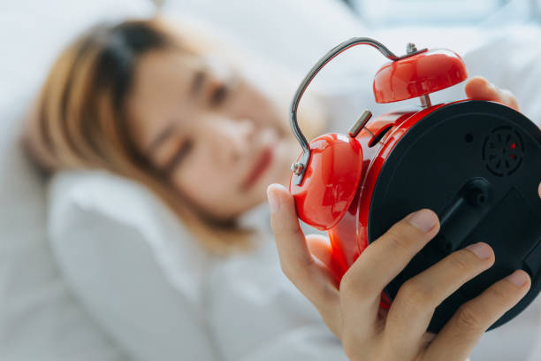 istock Asian woman look at red alarm clock. 1280863155