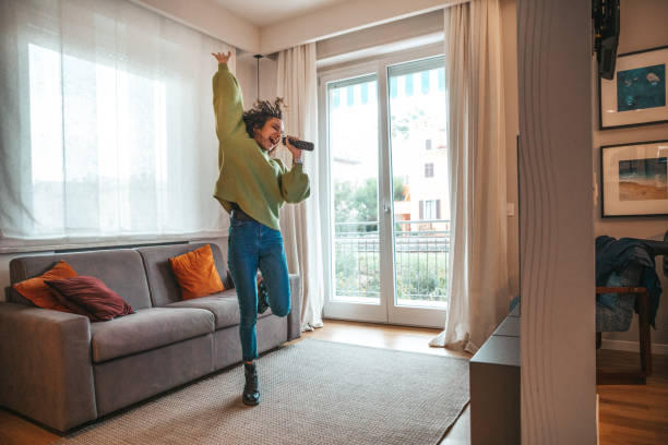 mujer feliz cantando en la sala de estar - living room people joy happiness fotografías e imágenes de stock