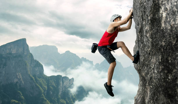istock Asian man rock climber in black pants climbing on the cliff. 1280864048