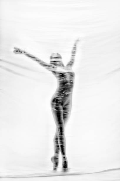 bailarina elegante bailando con nylon transparente - fantasy women blurred motion studio shot fotografías e imágenes de stock