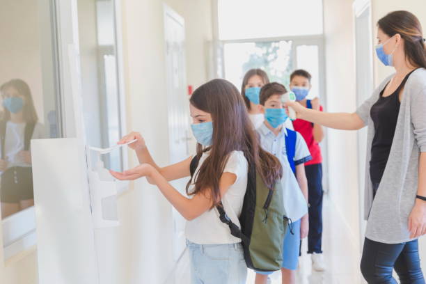 istock Little girl disinfecting hands while entering school. 1280865482