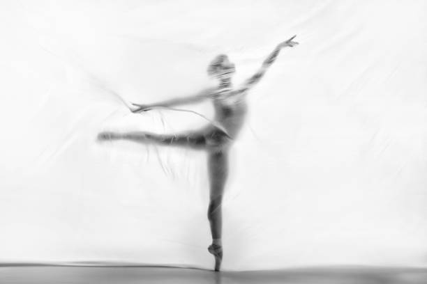 Graceful ballerina dancing with transparent nylon