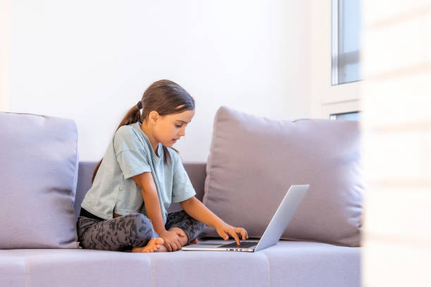 istock Cute little girl using laptop at home. Education, online study, home studying, distance learning, schoolgirl children lifestyle concept 1280867619