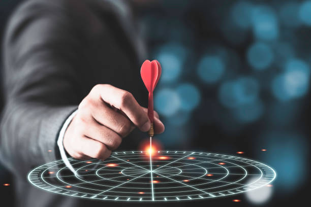 istock Businessman throwing red arrow dart to virtual target dart board. Setup objectives and target for business investment concept. 1280868874
