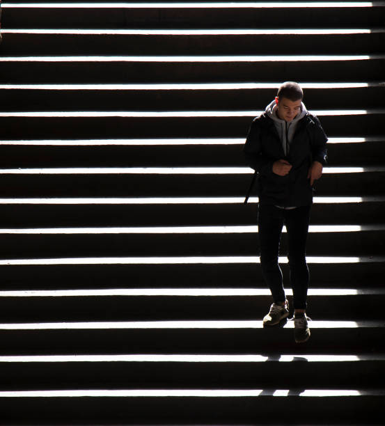 Man walking upstairs into the light.