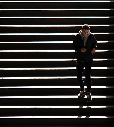 Belgrade, Serbia - October 09, 2020: Young man walking down city public stairs,  in high contrast