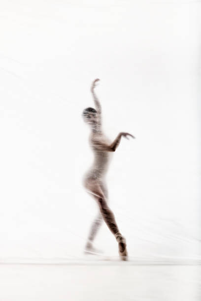 bailarina elegante bailando con nylon transparente - fantasy women blurred motion studio shot fotografías e imágenes de stock