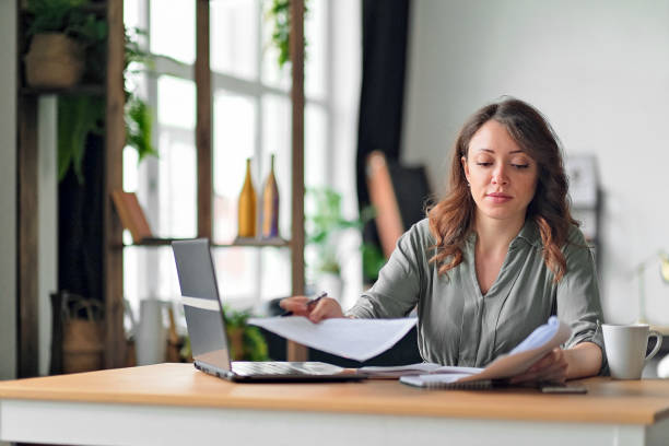 istock Young woman working from home office. Freelancer using laptop and the Internet. Workplace in living room 1280876492
