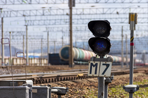 Vladivostok, Russia - April, 24, 2020: A semaphore with a blue signal against the background of railway tank cars with oil products at a freight station at the end of the Trans-Siberian Railway in Vladivostok.