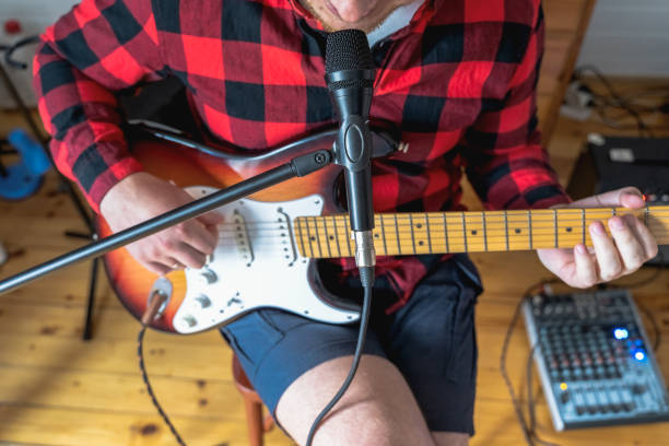 ung stilig man, musiker, sångare studera,öva för att spela elgitarr hemma,sjunga sånger i mikrofon. hobby,passion. kille i röd rutig skjorta sitter på stol. dj-konsol,högtalare,utrustning - foton med speaker bildbanksfoton och bilder