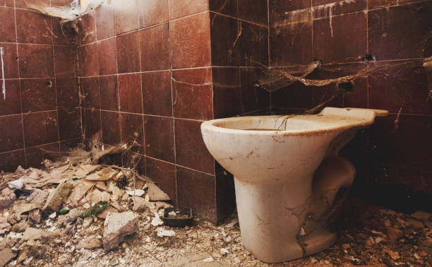stara zardzewiała brudna toaleta w opuszczonym domu, ceramiczna zatkana wc pochyliła się do obranejści. wnętrze strzał zniszczonego mieszkania ze zrujnowaną łazienką i brudną niehigienicznej toalety. naprawa - water pipe rusty dirty equipment zdjęcia i obrazy z banku zdjęć