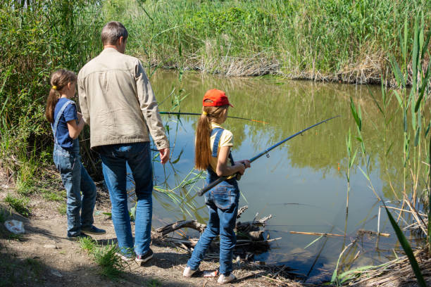 istock Dad with two daughters fishing on a lake 1280881254