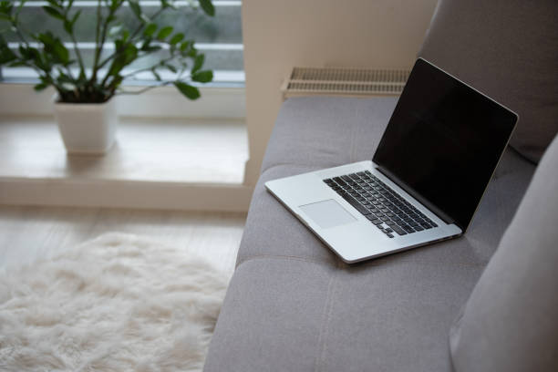 istock close up view of closed laptop lying on grey sofa 1280882393
