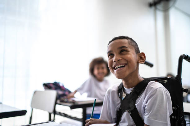 Happy wheelchair student studying in the classroom