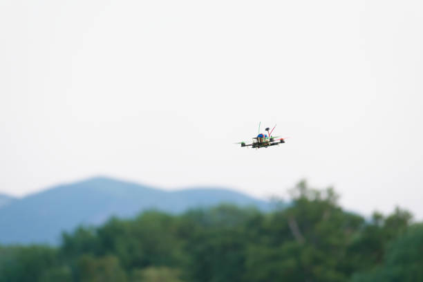 istock Home made racing quad copter FPV camera drone banks to fly past. 1280886423