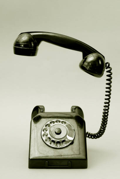 zabytkowy telefon z tarczą ze słuchawką uniesioną w powietrze. telefon w stylu retro w czerni i bieli. - 1950s style telephone image created 1950s rotary phone zdjęcia i obrazy z banku zdjęć