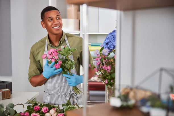 istock Cheerful young man during working day in flower shop 1280894974
