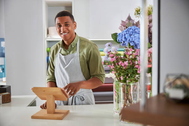 istock Happy young man making bouquets in salon 1280895036