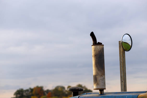 A close up image of an exhaust pipe on a tractor against a sky