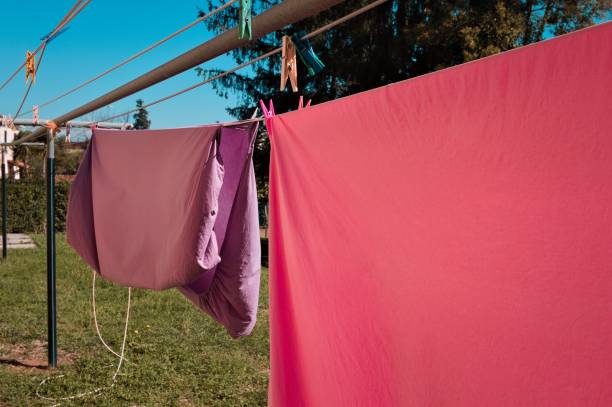 istock Pink an violed bed sheets hanging on a drying rack in the garden (Pesaro, Italy, Europe) 1280900302