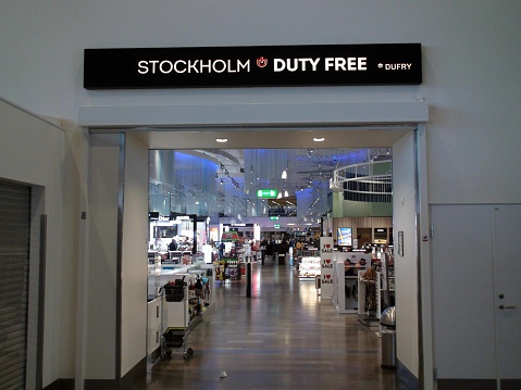 Advertisement Sign, Variety Of Items On Display For Sale, People Walking, Looking For Items To Buy At Stockholm Arlanda International Airport Duty Free In Sweden Northern Europe