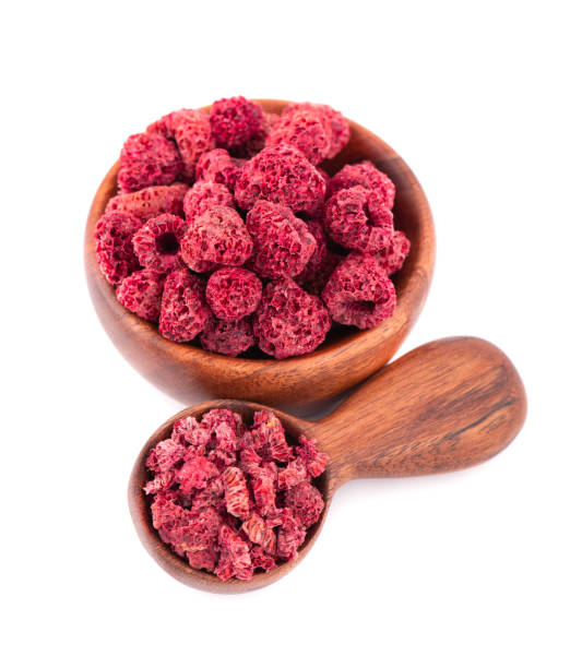 istock Dried raspberry isolated on white background. Dehydrated raspberry in wooden bowl and spoon. 1280902109