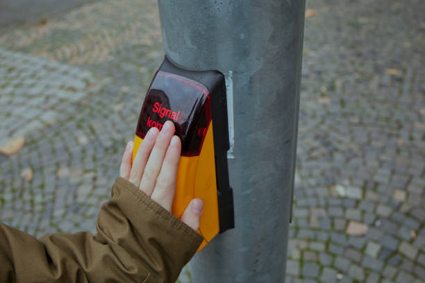child hand on a button to switch a pedestrian traffic light stock photo