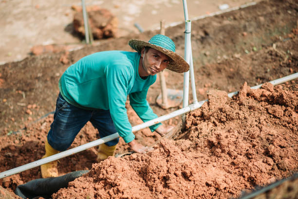 Asian male farmer cover canvas on the soil fields farmer looking at camera while working long sleeved recreational pursuit horizontal looking at camera stock pictures, royalty-free photos & images