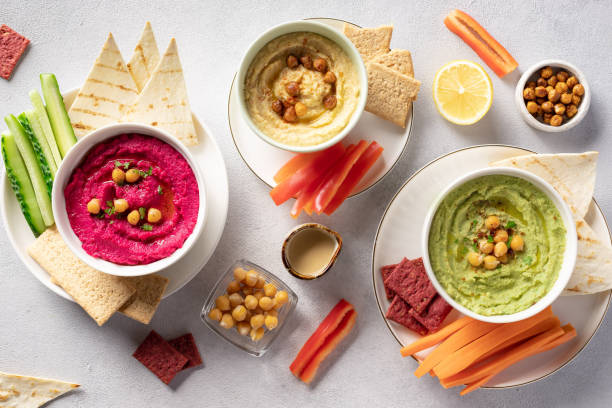 istock Various hummus dips in bowls, served with fresh vegetables and crisps 1280908471