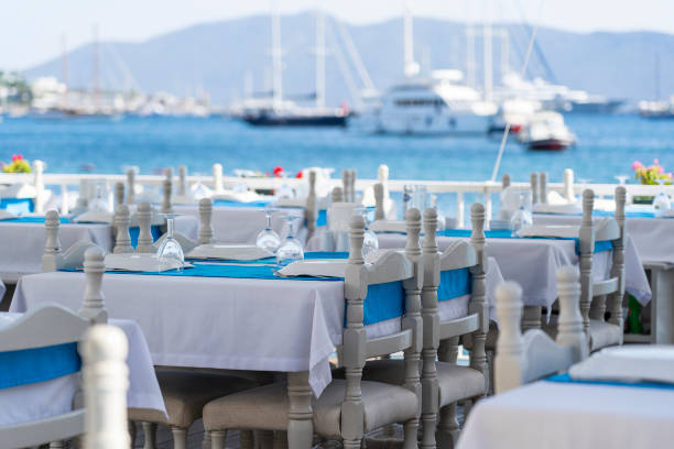 istock Elegant table setting with fork, knife, wine glass, white plate and blue napkin in restaurant . Nice dining table set with arranged silverware and napkins for dinner 1280911819