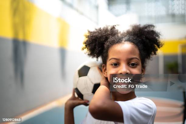 Portrait Of A Happy Girl Holding A Soccer Ball During Physical Activity Class Stock Photo - Download Image Now