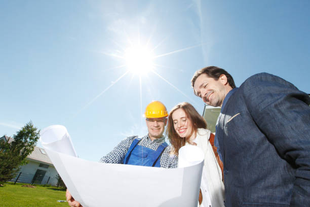 istock Foreman and couple hold blueprint 1280913366