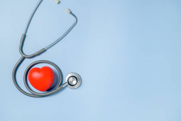 istock red heart and stethoscope isolated on blue background, 1280915461