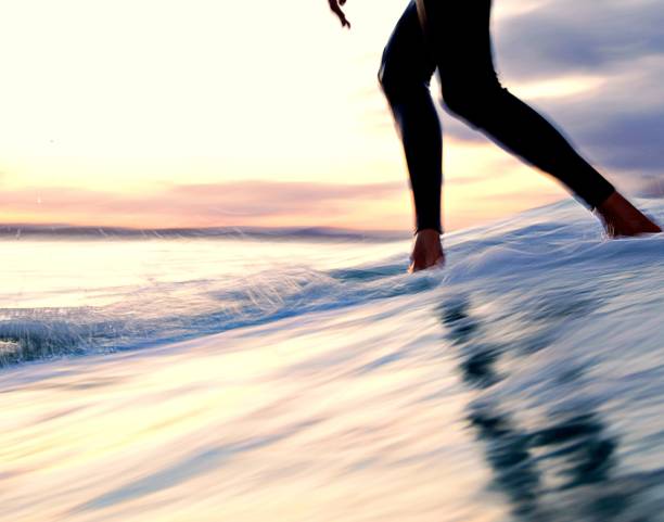 istock Slow shutter - Longboarder cross stepping up a surfboard at sunset 1280917667