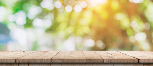 istock Empty wood table and defocused bokeh and blur background of garden trees with sunlight. product display template. 1280918980