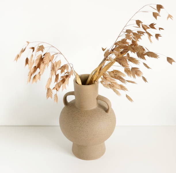 istock Beige dry reeds in vase standing on white wall . Minimal interior background. 1280920824