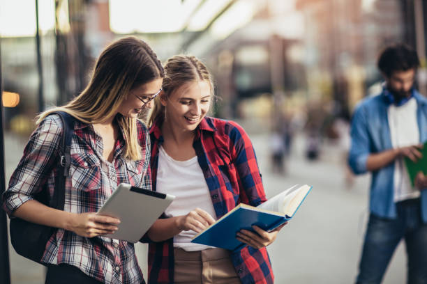 istock Happy young university students friends studying with books and digital tablet at university 1280922288