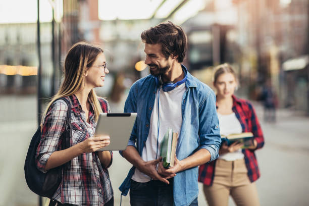 istock Happy young university students friends studying with books and digital tablet at university 1280922356