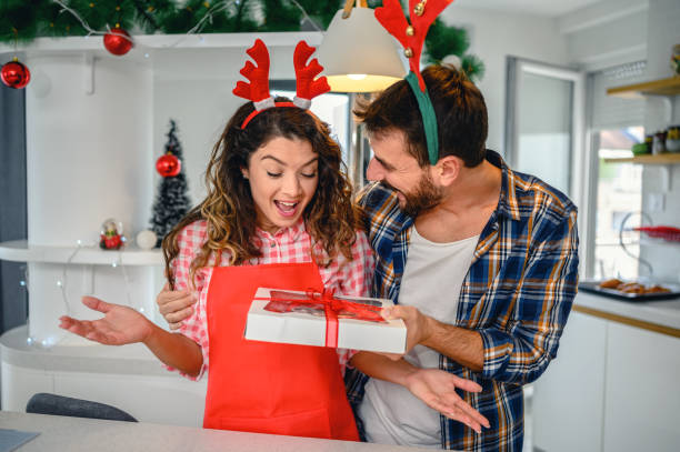 istock Couple holding Christmas presents with cookies 1280924711