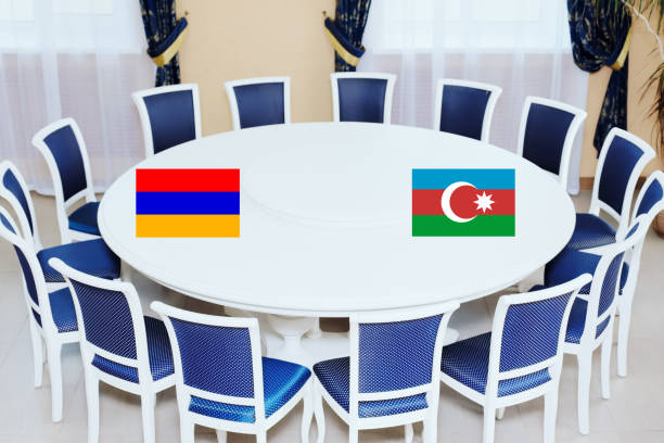 flags of azerbaijan and armenia at the round table. the truce of the warring parties or diplomatic negotiations - warring imagens e fotografias de stock