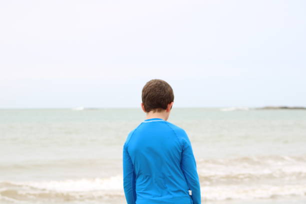 istock boy walking by the sea 1280931998