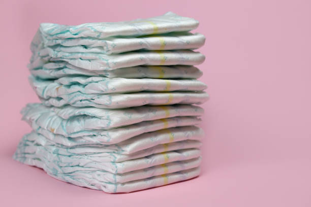 stack of diapers on a pink background, baby hygiene products stack of diapers on a pink background, baby hygiene products bottom the weaver stock pictures, royalty-free photos & images