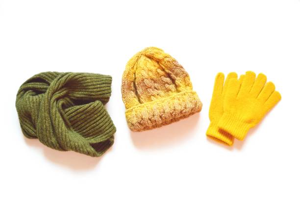 緑のウールのスカーフ、黄色のニット帽子、手袋は白い背景に隔離されています。秋と冬の服を平らに敷く。スタイリッシュな衣装のための明るいアクセサリー - scarf hat green glove ストックフォトと画像