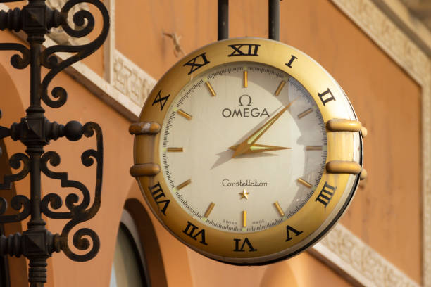 horloge omega sur le mur d’un bâtiment sur nevsky prospekt à saint-pétersbourg. - omega photos et images de collection