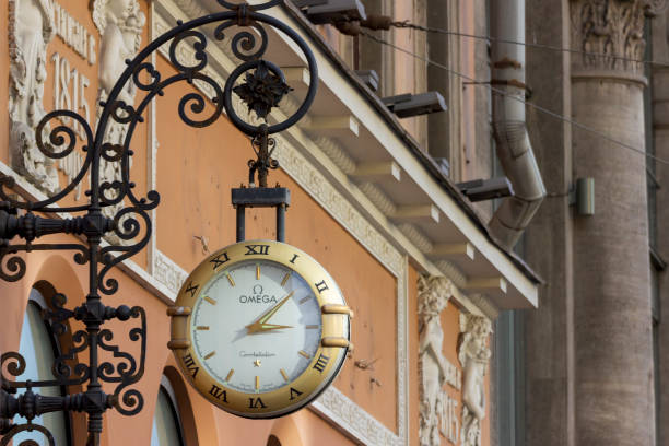 horloge omega sur le mur d’un bâtiment sur nevsky prospekt à saint-pétersbourg. - omega photos et images de collection