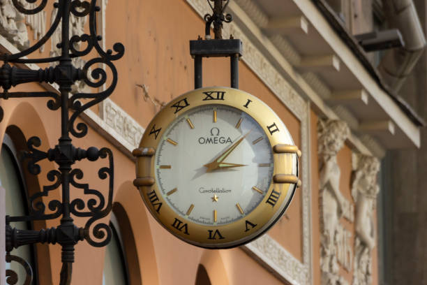 horloge omega sur le mur d’un bâtiment sur nevsky prospekt à saint-pétersbourg. - omega photos et images de collection